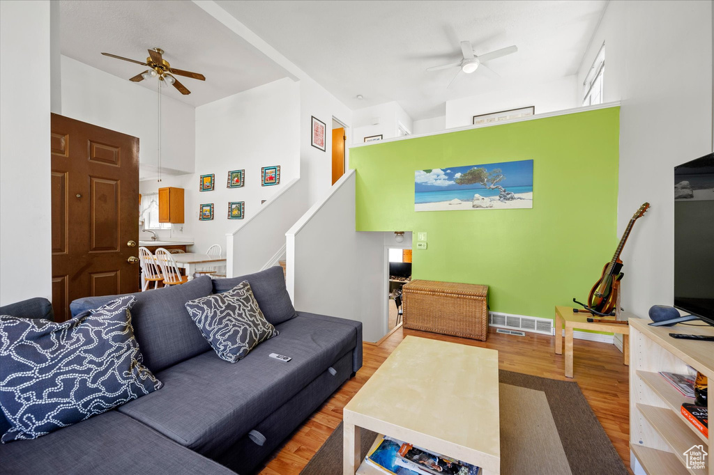 Living area with wood finished floors, a ceiling fan, and visible vents