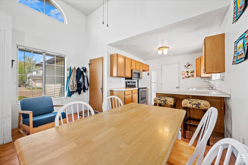 Dining area featuring a towering ceiling and light wood-style floors
