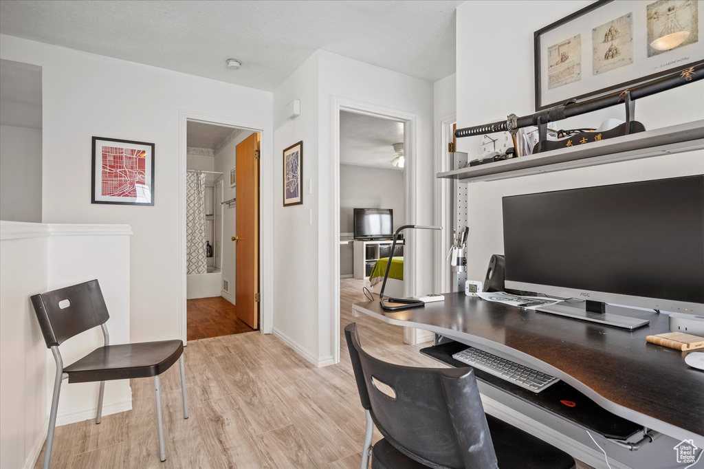 Office area with light wood-style floors and baseboards