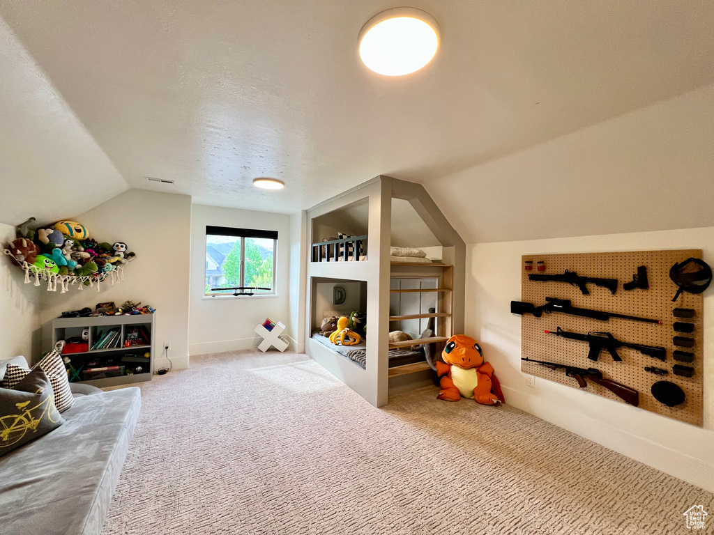 Bedroom with vaulted ceiling, carpet floors, and baseboards