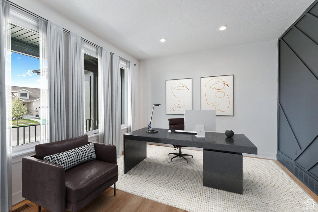 Office with plenty of natural light, recessed lighting, wood finished floors, and visible vents