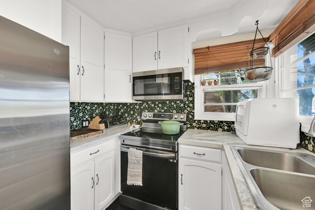 Kitchen with white cabinets, stainless steel appliances, and a sink