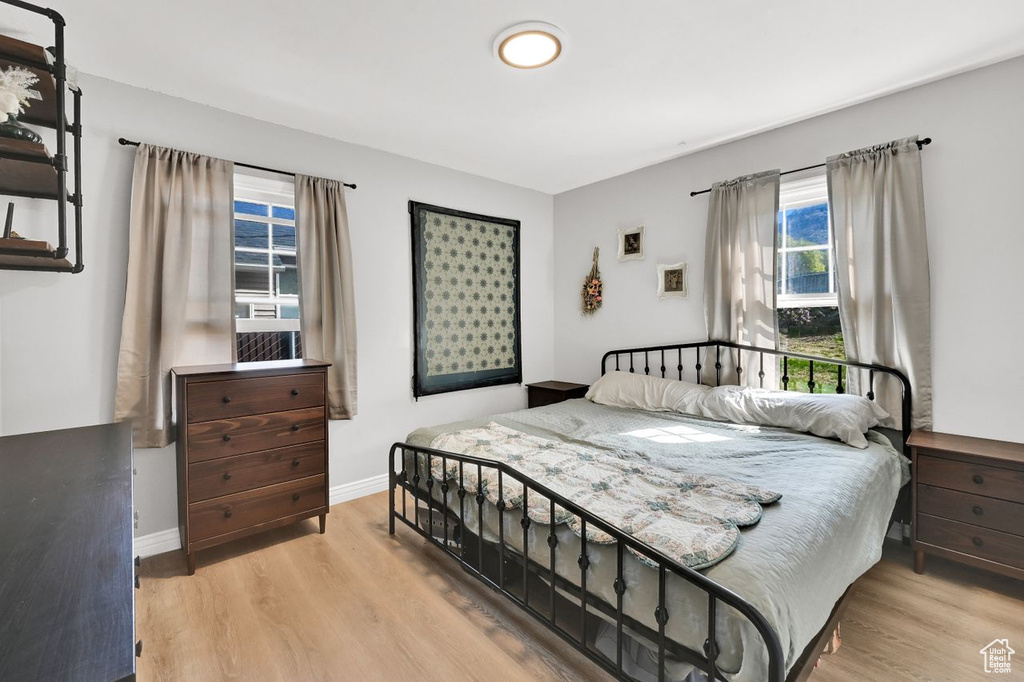Bedroom featuring light wood-style floors, baseboards, and multiple windows