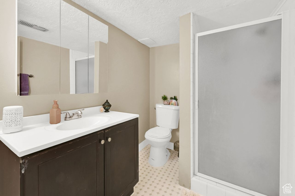 Full bath featuring tile patterned floors, a stall shower, vanity, toilet, and visible vents