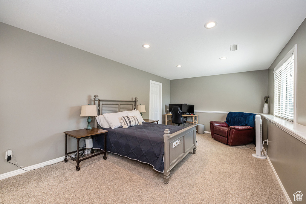 Bedroom with light colored carpet, baseboards, visible vents, and recessed lighting
