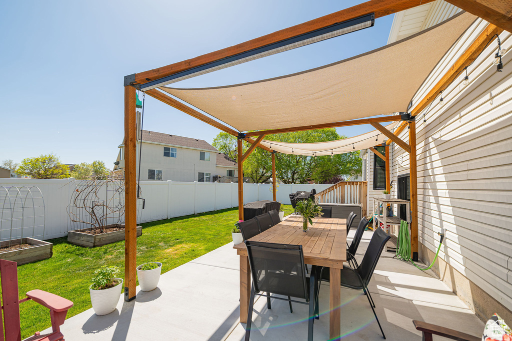 View of patio featuring a garden, outdoor dining area, and a fenced backyard