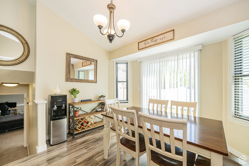 Dining area featuring lofted ceiling, wood finished floors, and plenty of natural light