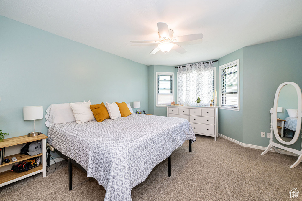 Carpeted bedroom with baseboards and ceiling fan