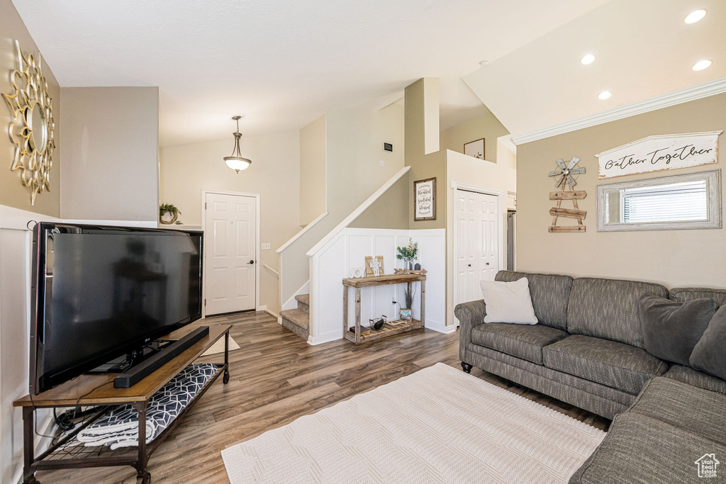 Living room with recessed lighting, stairway, lofted ceiling, and wood finished floors