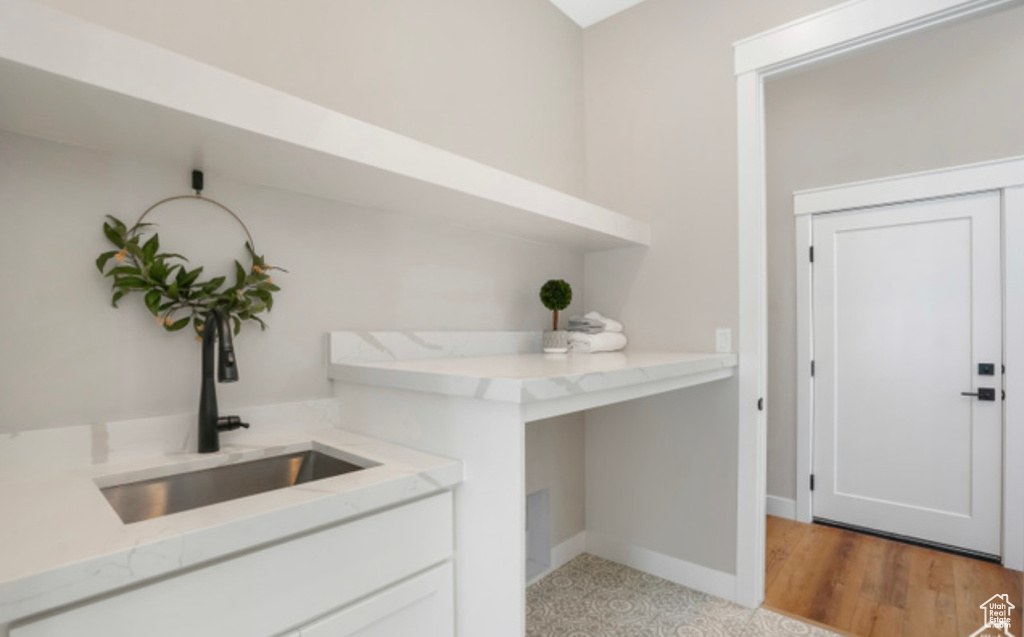 Bar featuring baseboards and a sink