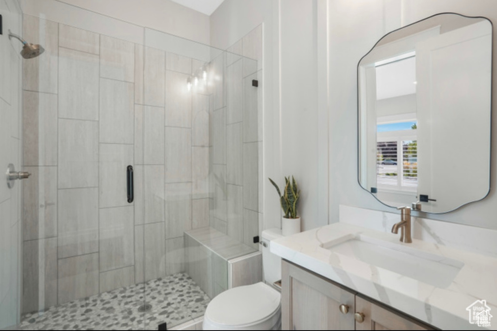 Full bath featuring toilet, vanity, and a stall shower