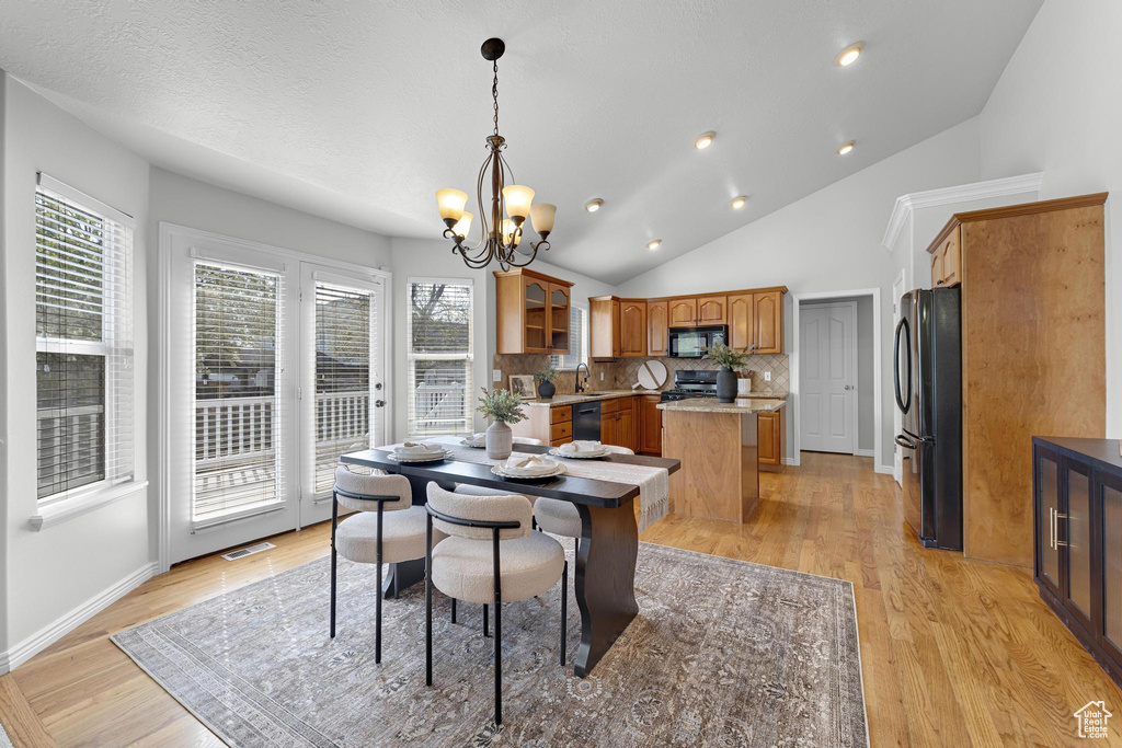 Dining room featuring recessed lighting, vaulted ceiling, visible vents, light wood-style floors, and a notable chandelier