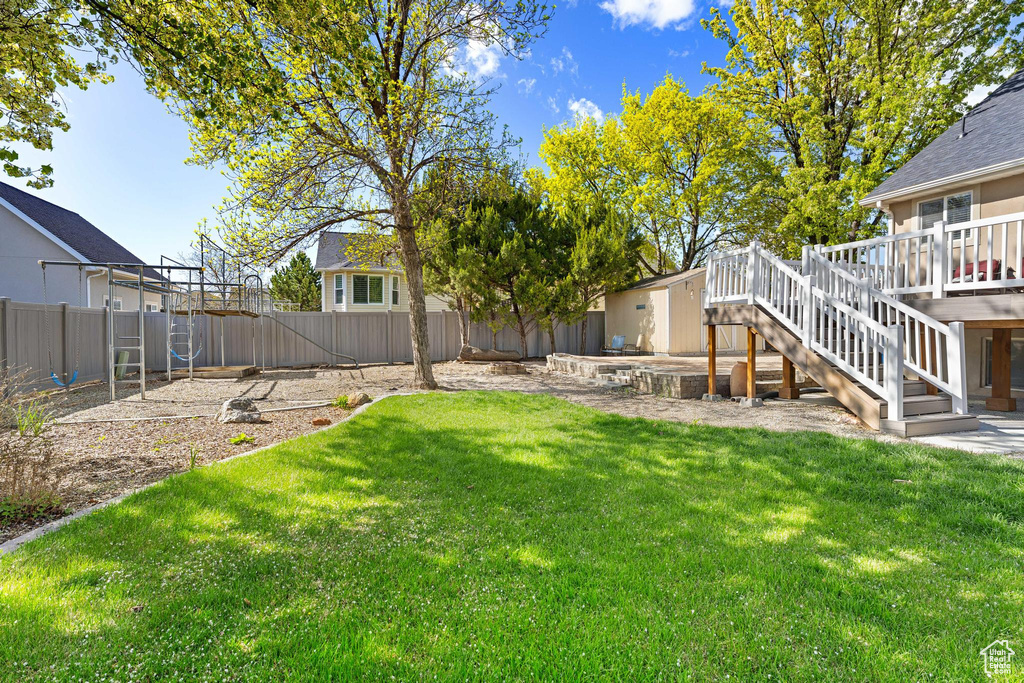 View of yard with stairway, a fenced backyard, and a deck