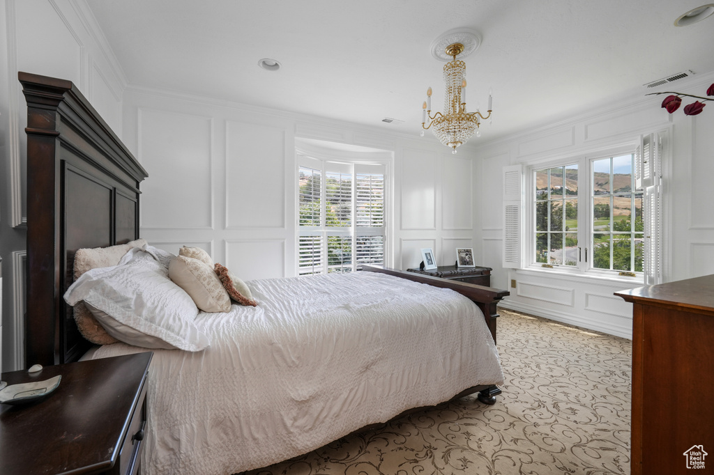 Bedroom with a decorative wall, crown molding, a chandelier, and recessed lighting