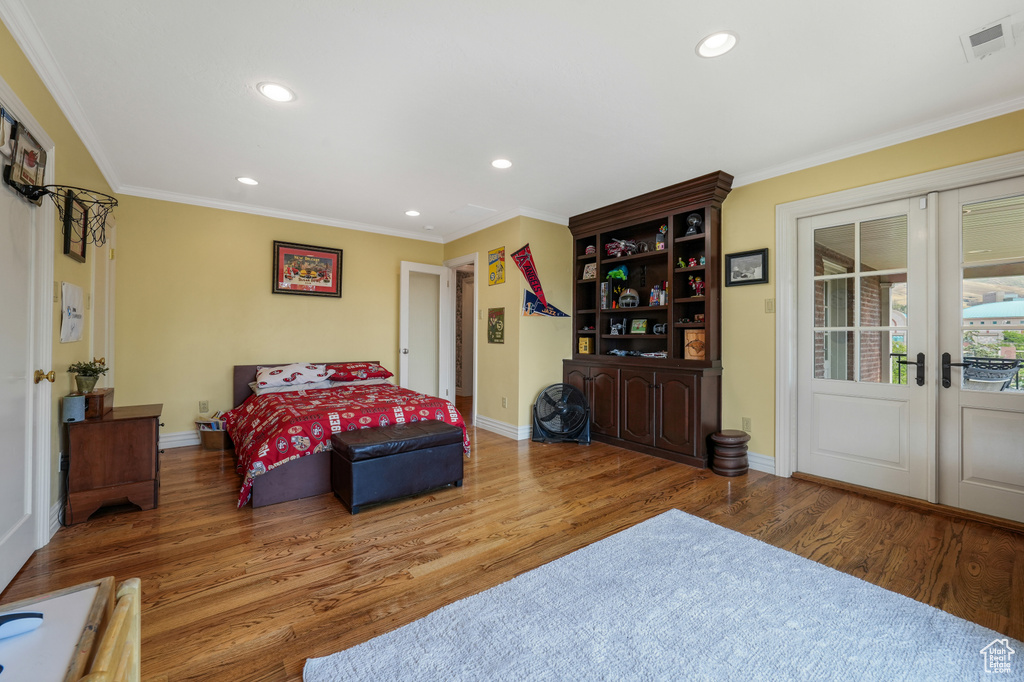 Bedroom with french doors, recessed lighting, wood finished floors, ornamental molding, and access to exterior