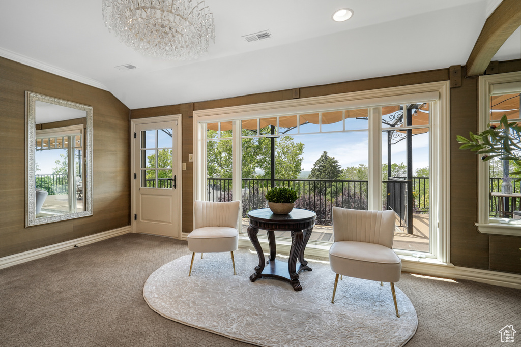 Living area with carpet, a chandelier, healthy amount of natural light, and lofted ceiling