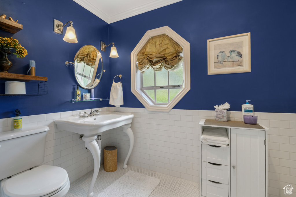 Bathroom featuring tile walls, a wainscoted wall, tile patterned flooring, and ornamental molding