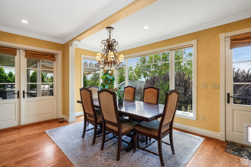 Dining room with a chandelier, light wood-style floors, ornamental molding, and recessed lighting