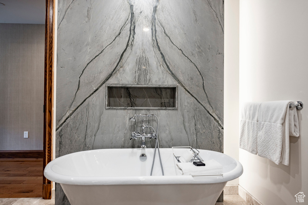 Bathroom with a soaking tub and baseboards