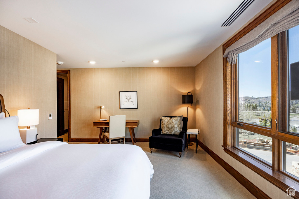 Bedroom featuring visible vents, wallpapered walls, light carpet, and baseboards