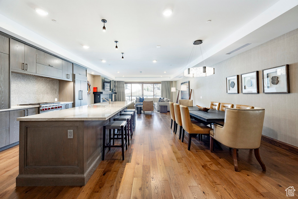 Kitchen featuring open floor plan, light countertops, range, and light wood-style floors