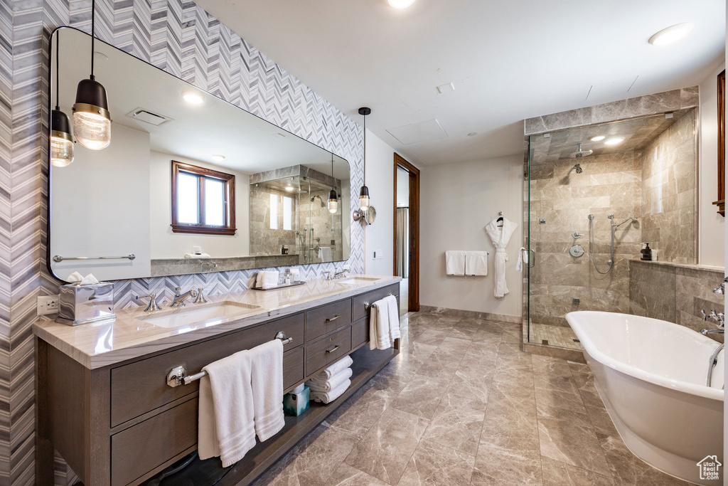 Full bath featuring a freestanding bath, a stall shower, and a sink