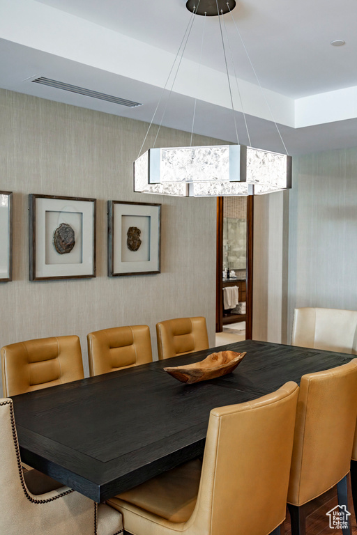 Dining room with wallpapered walls and visible vents