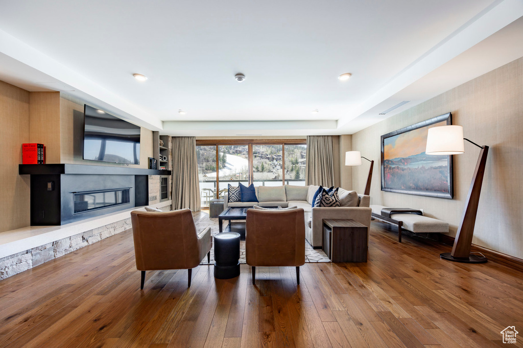 Living room featuring a glass covered fireplace and hardwood / wood-style flooring