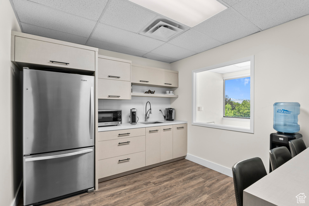 Kitchen featuring appliances with stainless steel finishes, light countertops, a paneled ceiling, open shelves, and dark wood-style flooring