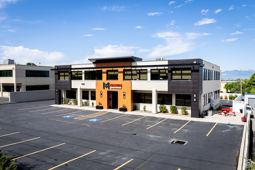 View of building exterior featuring uncovered parking and a mountain view