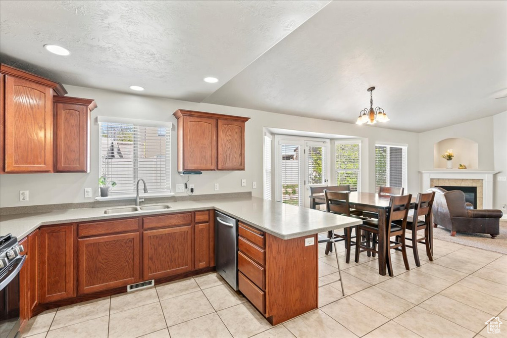 Kitchen with a peninsula, stainless steel appliances, a sink, and plenty of natural light