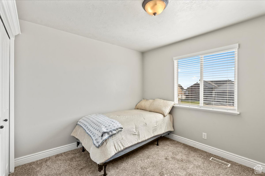 Bedroom featuring a closet, carpet floors, visible vents, and baseboards