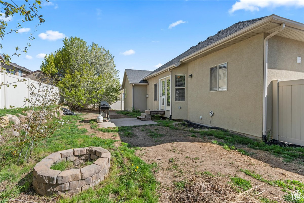 View of yard with fence, a patio area, and a fire pit