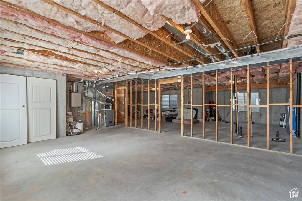 Unfinished basement with heating unit and water heater