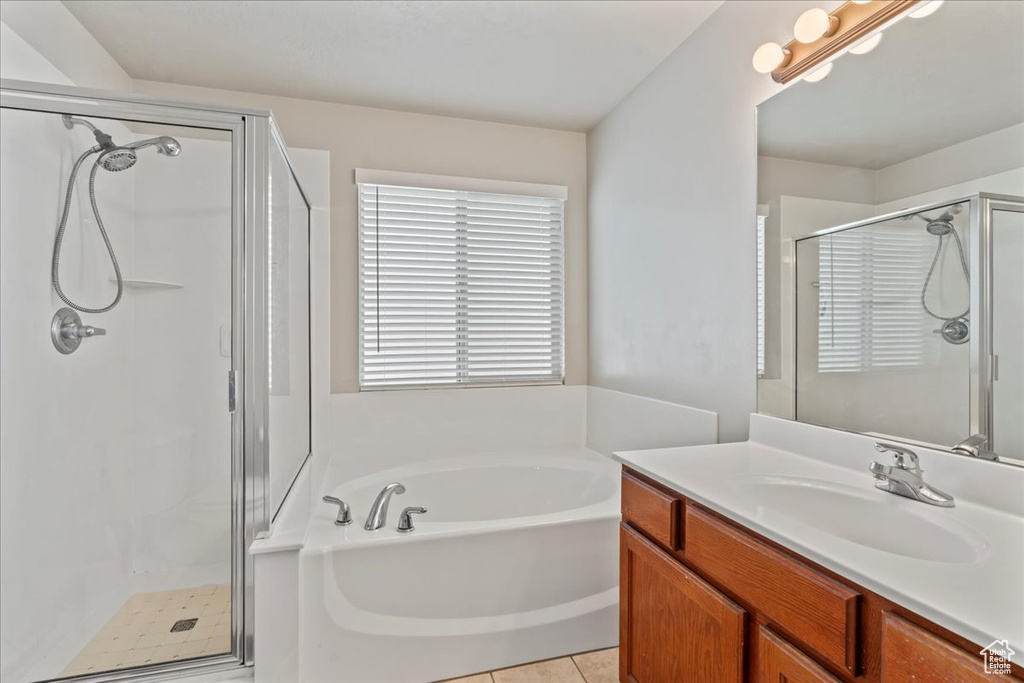 Full bathroom featuring tile patterned flooring, a garden tub, vanity, and a stall shower