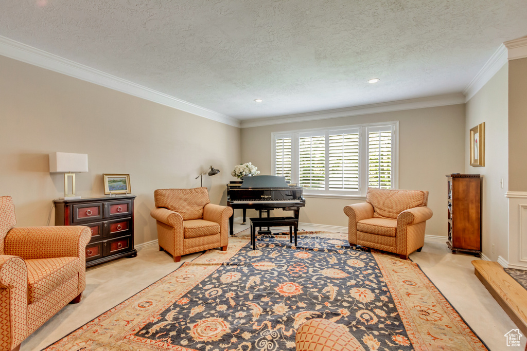 Living area with recessed lighting, a textured ceiling, light colored carpet, and crown molding
