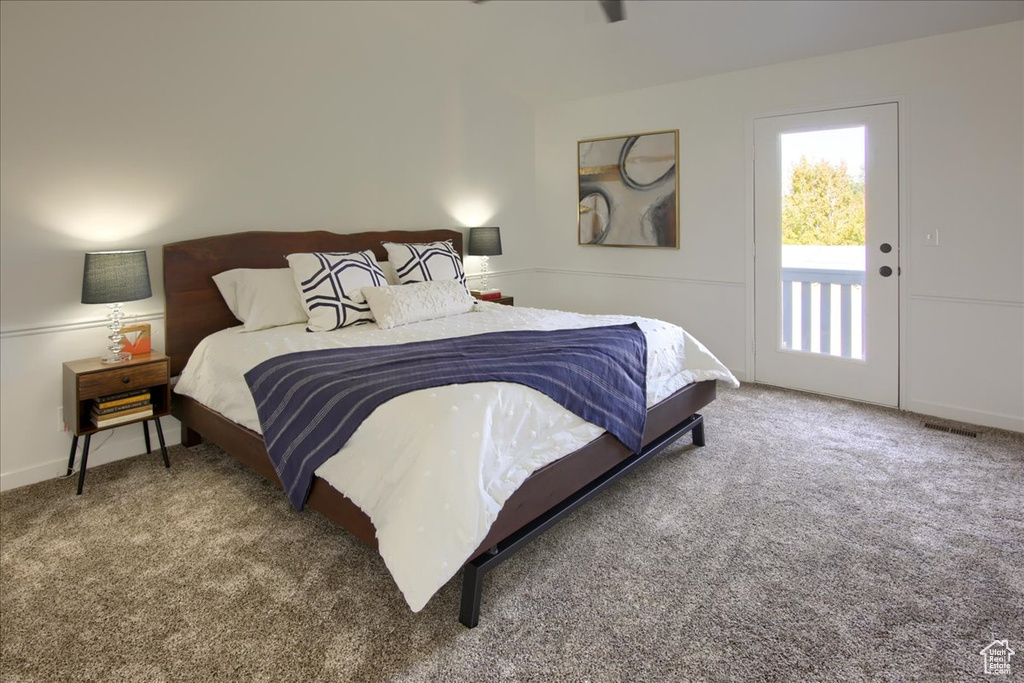Carpeted bedroom with visible vents and access to outside