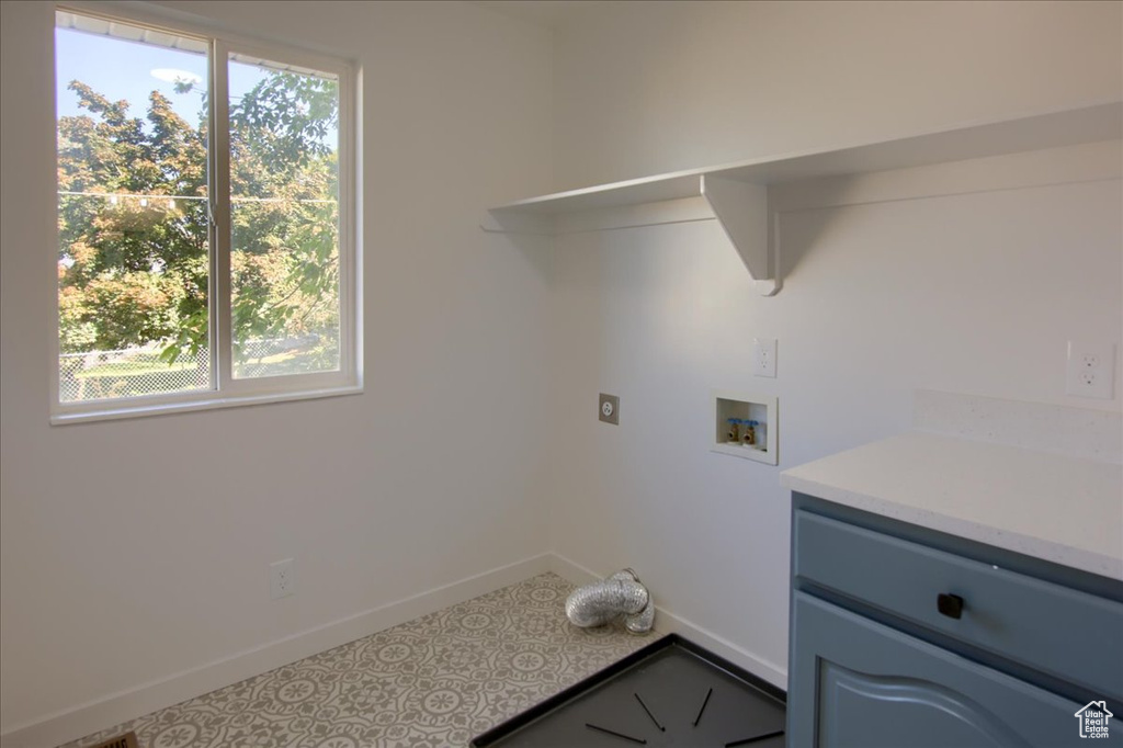 Laundry area with baseboards, a healthy amount of sunlight, and washer hookup