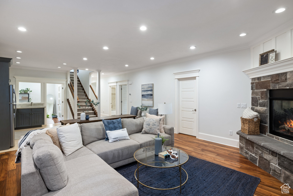Living area featuring recessed lighting, stairs, and ornamental molding