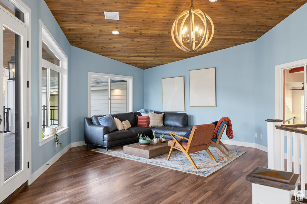 Living room with baseboards, vaulted ceiling, wooden ceiling, and a chandelier