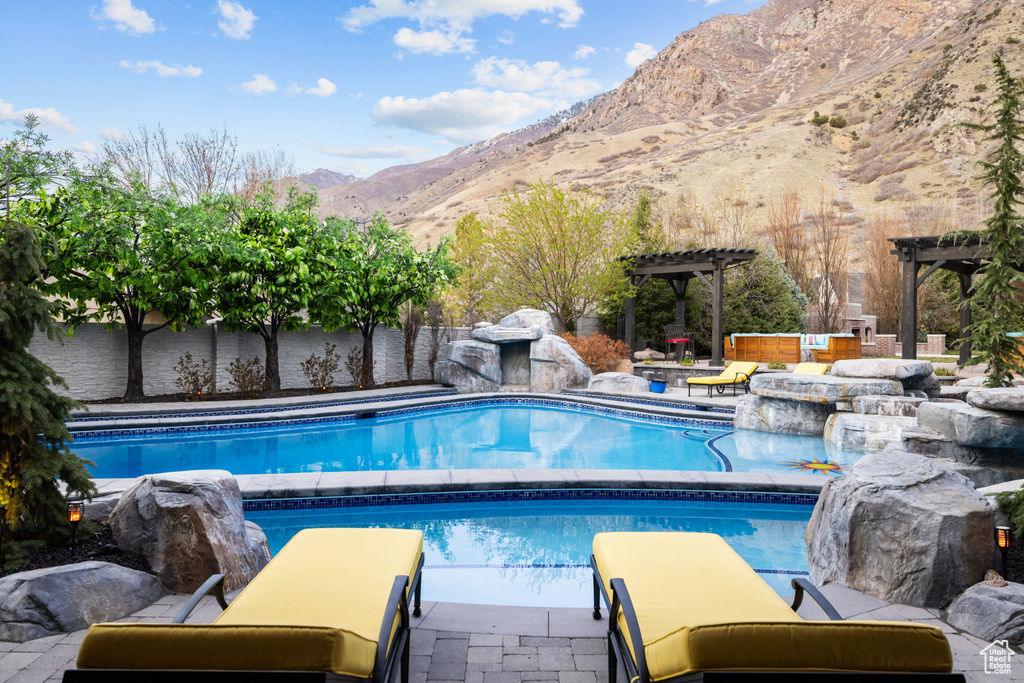Pool featuring a mountain view, a patio, and a pergola