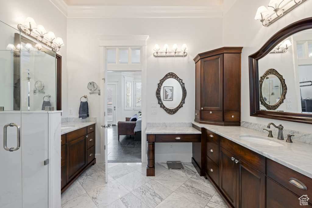 Full bathroom featuring marble finish floor, two vanities, ornamental molding, and a sink