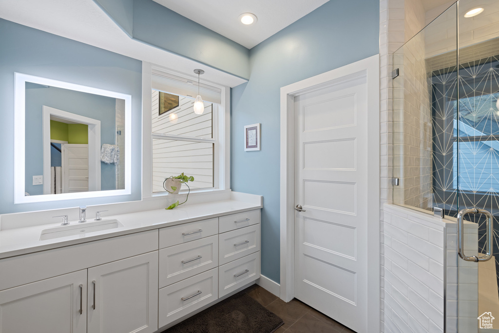 Full bath with a shower stall, vanity, and tile patterned flooring