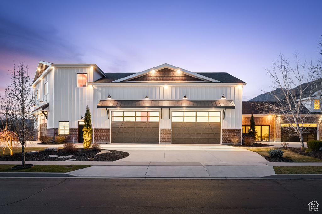 Modern farmhouse style home featuring brick siding, board and batten siding, and concrete driveway
