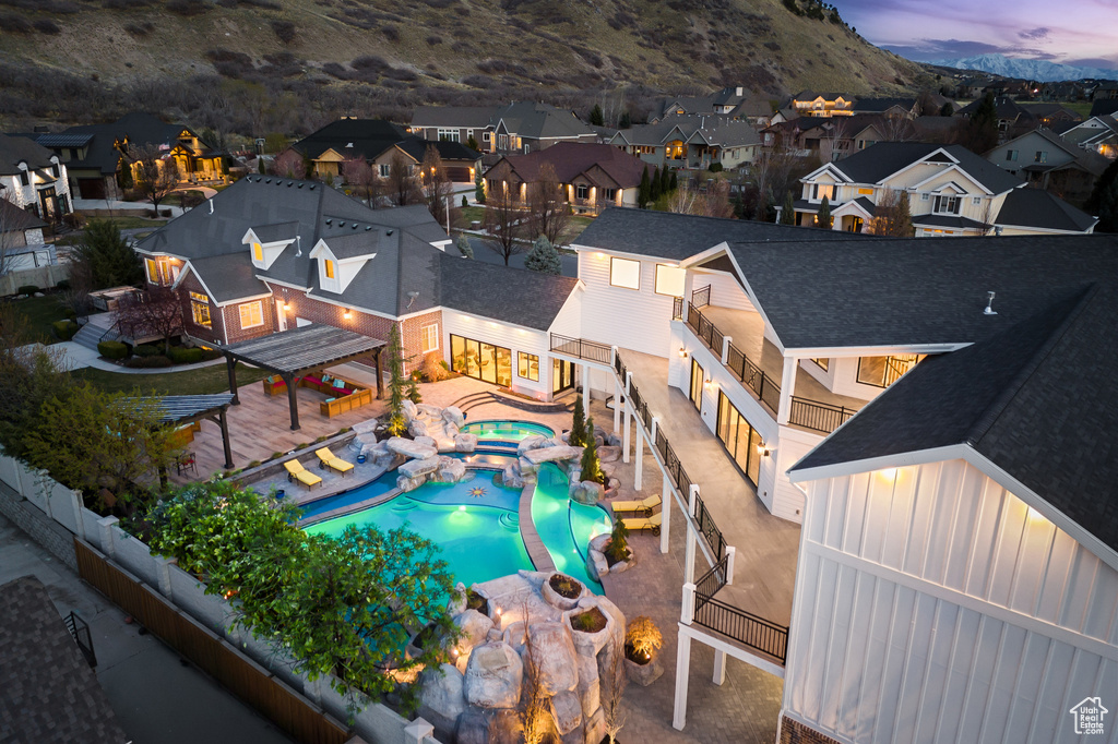 View of swimming pool with a fenced backyard, a residential view, a patio area, a mountain view, and a pool with connected hot tub