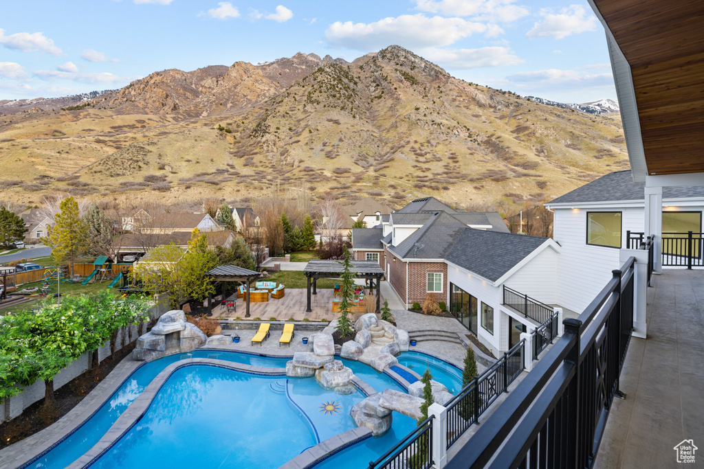 View of swimming pool featuring a pool with connected hot tub, a patio, a fenced backyard, and a mountain view