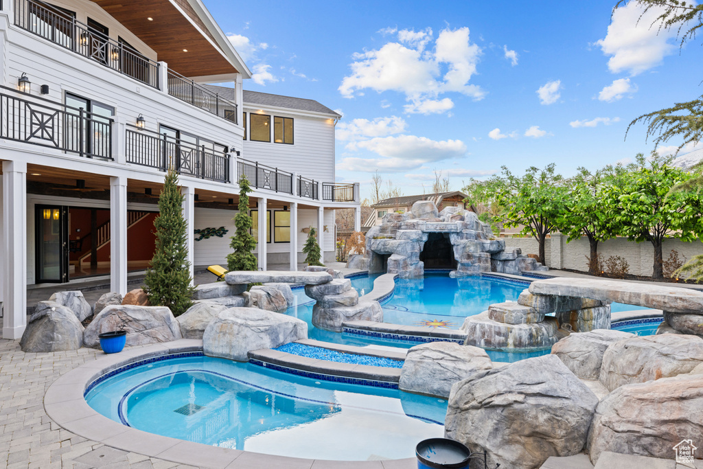Pool with a patio area and an in ground hot tub