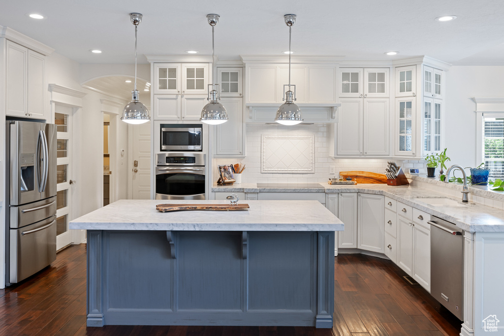 Kitchen featuring white cabinetry, a sink, dark wood-type flooring, and appliances with stainless steel finishes
