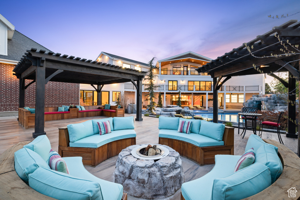 View of patio / terrace featuring an outdoor pool, an outdoor living space with a fire pit, a balcony, and a deck