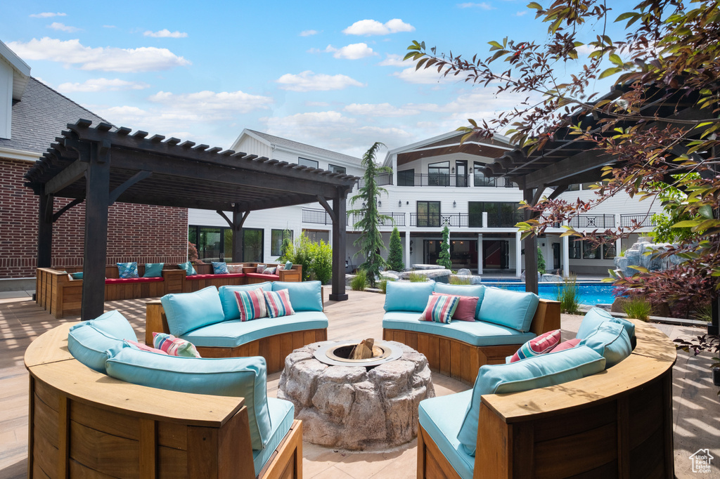 View of patio featuring an outdoor living space with a fire pit, a pergola, and an outdoor pool